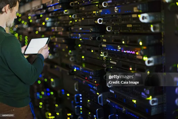 Server room technician using digital tablet